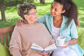 caregiver giving some tea to the senior woman